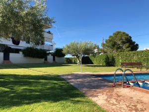 uma piscina com parque infantil ao lado de um edifício em La Ampolla Beach - Cap Roig em L'Ampolla