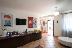 a living room with a desk and a tv on the wall at B&B Monelli in Diso