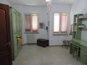 una sala de estar con armarios verdes y ventanas en Casa Dario, en Melissano