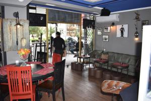 a restaurant with a table and chairs and a couch at Hotel Orbi Plaza in Batumi