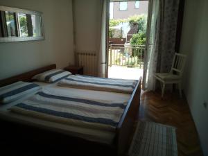 sypialnia z łóżkiem, oknem i krzesłem w obiekcie Apartments Mirela w mieście Novigrad