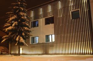 a building with a snow covered tree in front of it at Rever in Mielec