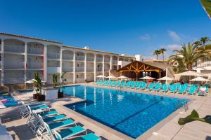 un hôtel avec une piscine et des chaises longues dans l'établissement Hotel Vibra Cala Tarida-3SUP, à Cala Tarida