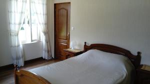 a bedroom with a bed and a window at La petite maison normande in Ticheville