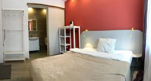 a bedroom with a bed and a red wall at Emilia - У центрі міста, Приватне паркування в закритому дворі in Mukacheve
