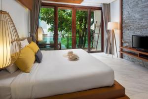a bedroom with a large white bed with yellow pillows at Idyllic Concept Resort in Ko Lipe