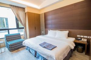 une chambre d'hôtel avec un lit et une chaise dans l'établissement Hu Shan Hot Spring Hotel, à Taian