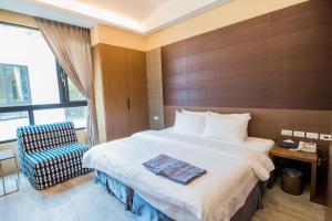 a hotel room with a bed and a chair at Hu Shan Hot Spring Hotel in Taian