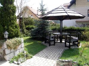 Una mesa de picnic con sombrilla y dos bancos. en Apartmani Višnja, en Zlatibor