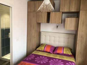 a small bed in a room with wooden cabinets at Altéa in Pessac