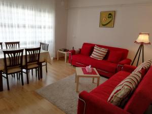 a living room with a red couch and a table at شقق مفروشة غرفتين وصالون 110 in Bursa