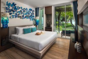 a bedroom with a large white bed with blue accents at Idyllic Concept Resort in Ko Lipe