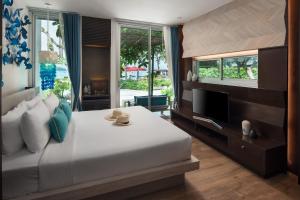a bedroom with a large bed and a television at Idyllic Concept Resort in Ko Lipe