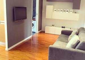 ein Wohnzimmer mit einem Sofa und einem Flachbild-TV in der Unterkunft D@HOME in Rom