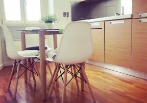 una cucina con tavolo e due sedie bianche di D@HOME a Roma