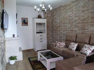 a living room with a couch and a brick wall at Casa de Joaquina in O Grove
