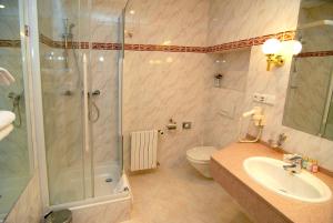 een badkamer met een douche, een wastafel en een toilet bij Hotel Opera in Praag