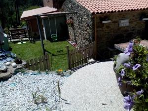 un jardín con una valla de madera y algunas flores en Casa Louro, en Frije