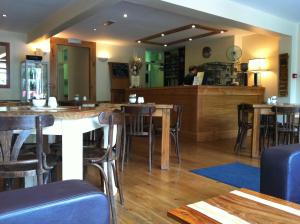 a restaurant with wooden tables and chairs and a counter at Bridge View Guest House in Ironbridge