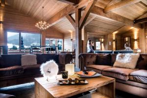 a living room with couches and a coffee table at Résidence - Les Grandes Alpes in La Clusaz