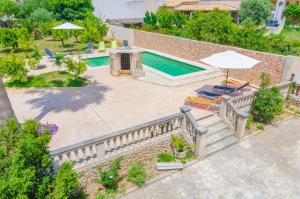widok na basen z krzesłami i parasolem w obiekcie Casa Canals w mieście Mancor del Valle