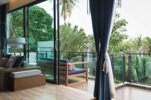 a room with a balcony with a blue chair at Idyllic Concept Resort in Ko Lipe
