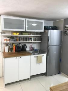 a kitchen with white cabinets and a stainless steel refrigerator at Apartment Caesarea 38 in Caesarea