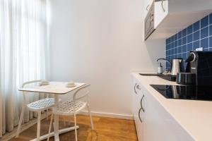 una cucina con un tavolino e due sgabelli di Dream Chiado Apartments a Lisbona