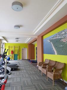 un gimnasio con sillas y una gran pintura en la pared en Apartament pomarańczowy z basenem,sauną-blisko morza. en Kołobrzeg