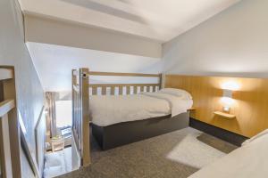 a small room with a bed and a staircase at B&B HOTEL Boulogne Sur Mer in Saint-Martin-Boulogne