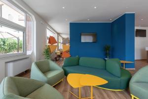 a living room with a couch and two chairs at Hotel Riva in Alassio