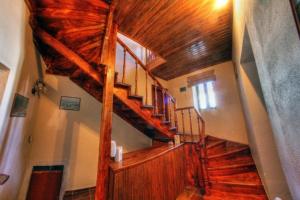 eine Holztreppe in einem Haus mit Holzdecke in der Unterkunft Philippos Hotel in Psarádes