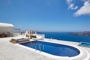a swimming pool on the side of a house with the ocean at Celestia Grand in Fira