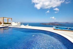 a swimming pool with a view of the ocean at Celestia Grand in Fira