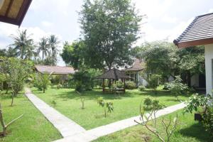 a garden with a gazebo and a house at Bidara Cottage in Labuhan Pandan