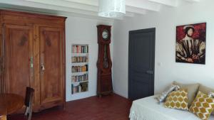 a living room with a clock and a bed and a book shelf at La Blinerie in Sambin