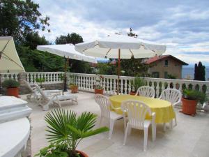 a patio with a table and chairs and an umbrella at Guesthouse Katarina in Opatija