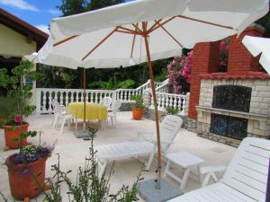 patio con tavolo, sedie e ombrellone di Guesthouse Katarina a Opatija