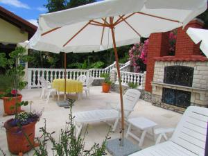 a patio with a table and chairs and an umbrella at Guesthouse Katarina in Opatija