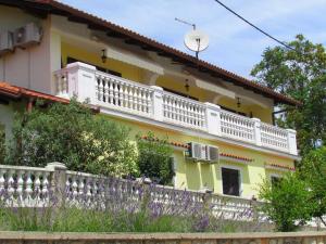 a yellow and white house with a white balcony at Guesthouse Katarina in Opatija