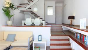 a living room with stairs with a couch and books at Casa Salinas in Morro del Jable