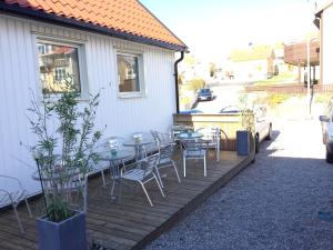 a wooden deck with tables and chairs on a house at Kajsa krabbat Vandrarhem in Kungshamn