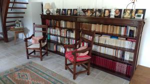 a book shelf filled with books next to two chairs at La Blinerie in Sambin
