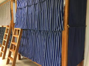 a bed with blue and white sheets and a ladder at Shimaotoya in Iriomote