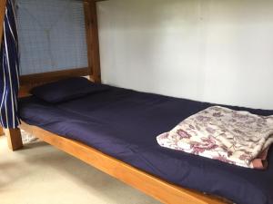 a bed in a room with a blue blanket on it at Shimaotoya in Iriomote
