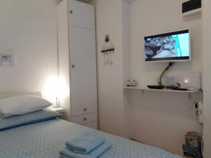 1 dormitorio con 1 cama y TV en la pared en Assi Room en Split