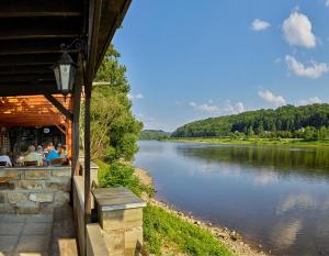 eine Gruppe von Menschen, die in einem Restaurant neben einem Fluss sitzen in der Unterkunft Hotel Elbparadies in Pirna