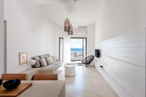a white living room with a couch and a table at Beach Bird Swallow in Megáli Panayía