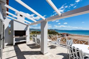 a patio with a fireplace and a view of the ocean at Beach Bird Swallow in Megáli Panayía