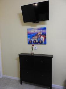 a black dresser with a flat screen tv on a wall at Las Flores studio 2 in Playa de las Americas